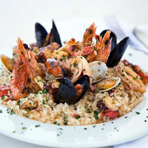 Un piatto di risotto ai frutti di mare, ricco e invitante, perfetto per una festa.