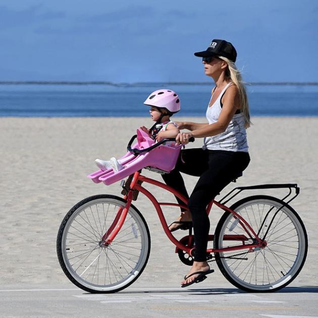 Madre e figlia in bici sulla spiaggia, sole splendente, gioia e libertà.