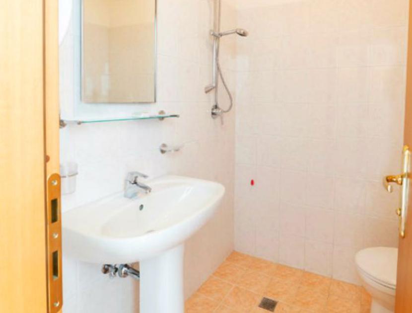 Bagno semplice e luminoso, con doccia, lavabo e wc, trasmette pulizia e funzionalità.